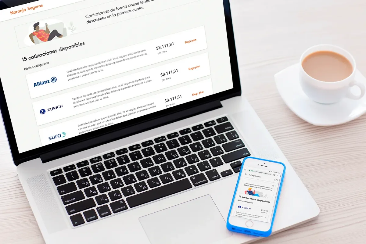 Computadora y teléfono mostrando interfaces digitales de contratación de seguros de auto.